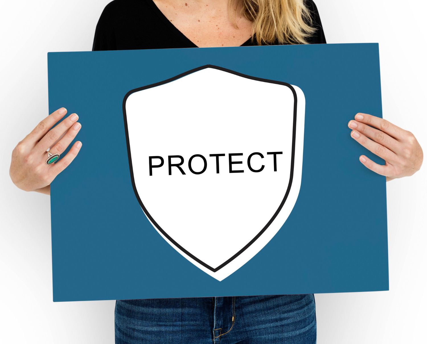 donna con in mano un cartello blu con al centro uno scudo bianco con scritto "protect"